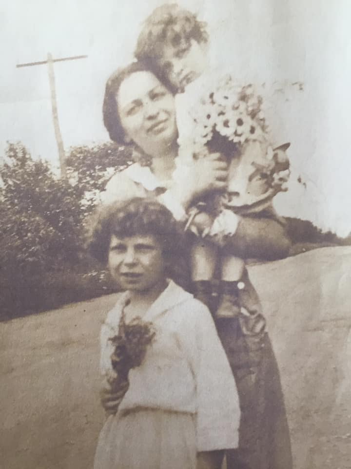 A sepia-toned photograph of Kipp Dawson's grandmother holding a toddler girl child with a young girl child standing in front of them.